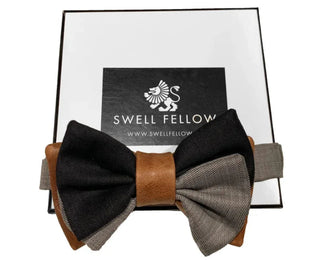 Men's two-tone black and gray bow tie with brown leather center on gift box