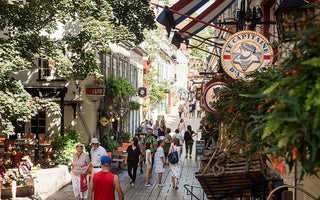 Bustling Quebec pedestrian street, boutique shops, Le Capitaine sign, people strolling