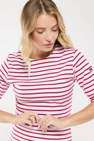 Woman wearing a white and red striped long-sleeve shirt with patch detail on sleeve