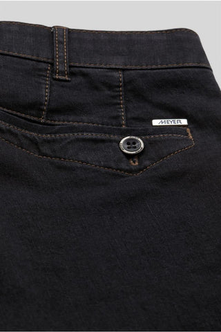 Close-up of dark denim Meyer jeans front pocket with brown stitching and metal button
