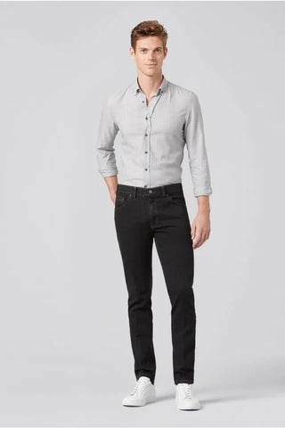 Man wearing slim fit black Meyer jeans, light grey shirt, and white sneakers