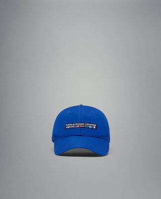 Blue nylon yachting cap with embroidered logo and nautical flags on the front, isolated background