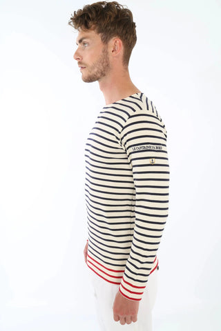 Man in navy and white striped long-sleeve shirt with 'Le Capitaine D'a Bord' text on sleeve