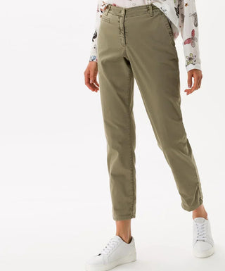 Woman wearing khaki cotton vintage pants with casual white sneakers and printed shirt