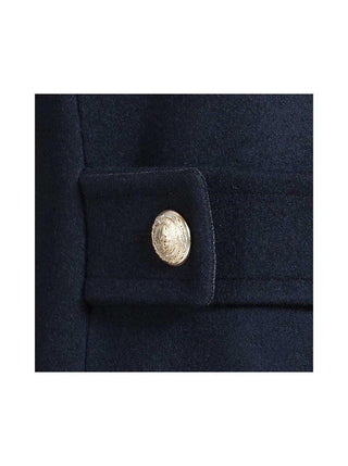 Close-up of navy wool coat with gold embossed button detail