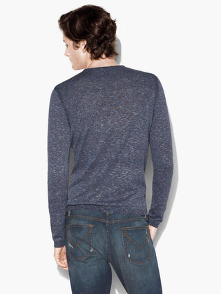 Man wearing a blue cotton crew neck sweater and denim jeans, shown from the back.