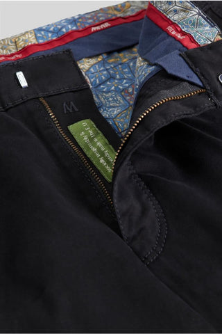 Close-up of black cotton pants with zipper and colorful patterned inner lining
