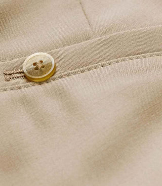 Close-up of beige lightweight wool trousers with button detail