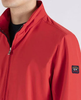 Red nylon men's jacket with zipper and patch detail on sleeve