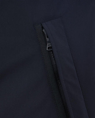 Close-up of dark navy nylon jacket with waterproof zippered pocket detail