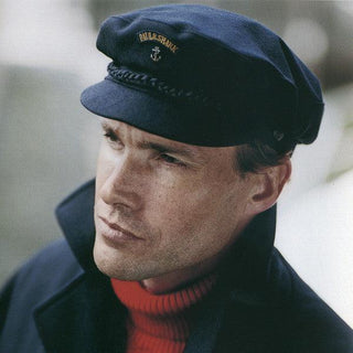 Man wearing a navy wool sailor cap with embroidered anchor, classic maritime fashion look