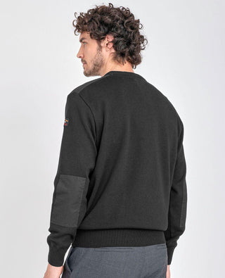 Man wearing black crew neck sweater with shoulder and elbow patches, back view