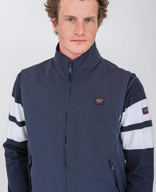 Man wearing navy nylon sleeveless vest with zip and striped long sleeves, sporty casual style